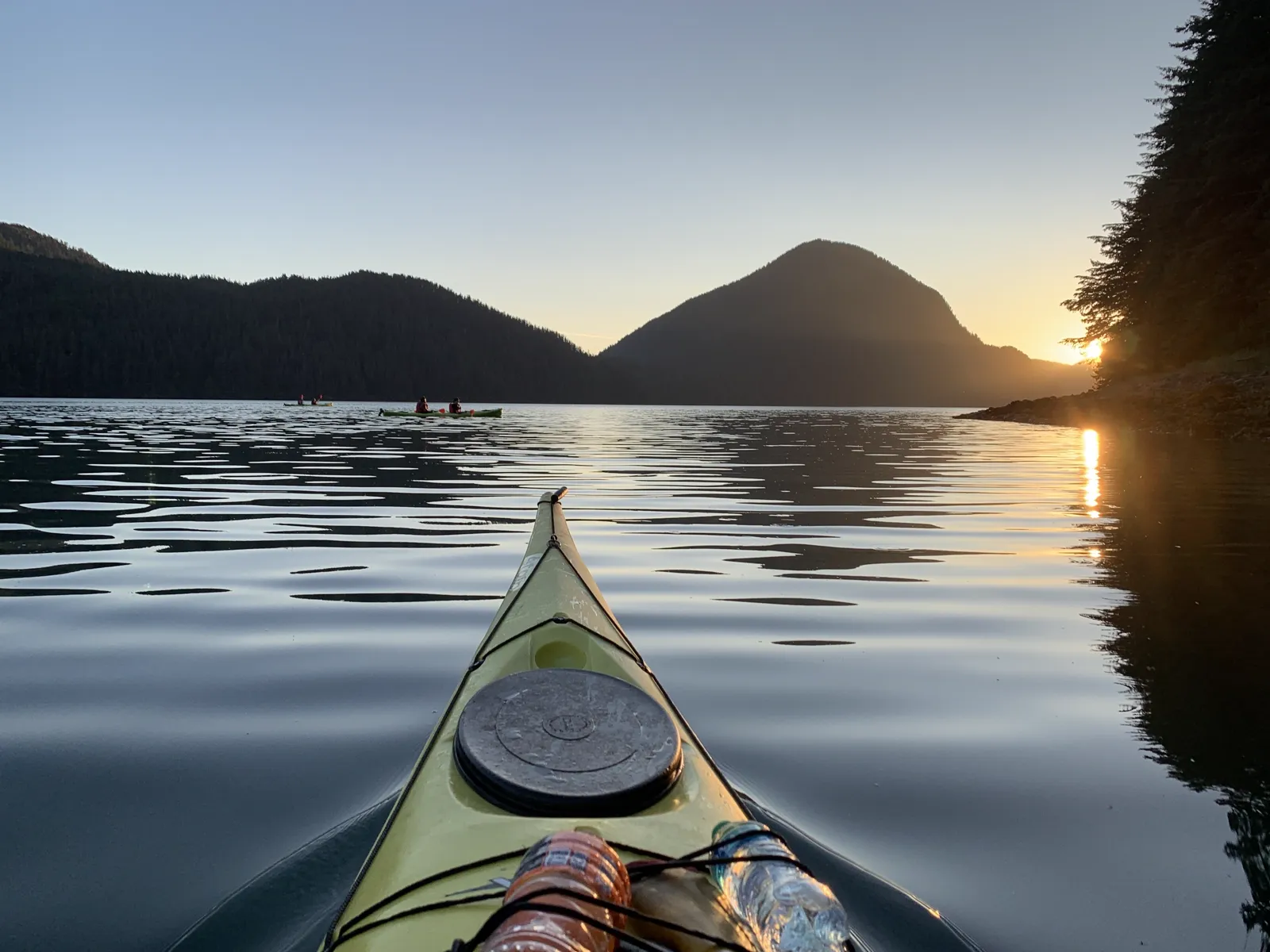 Sunset paddle on glassy water near Sitka, Alaska, with mountain silhouettes